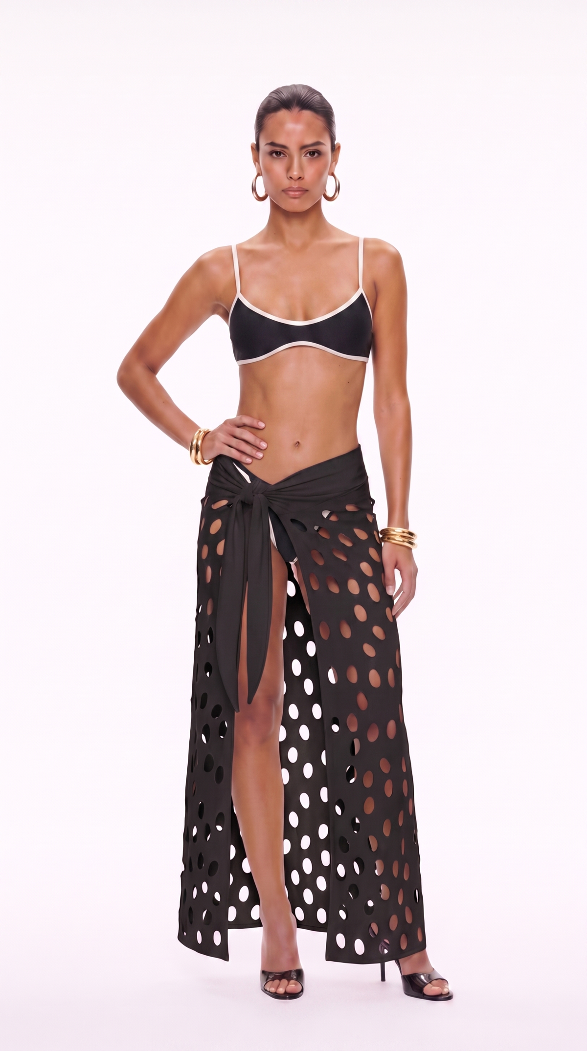 Front view of Eds black cutwork skirt with hip tie knot and oval perforations